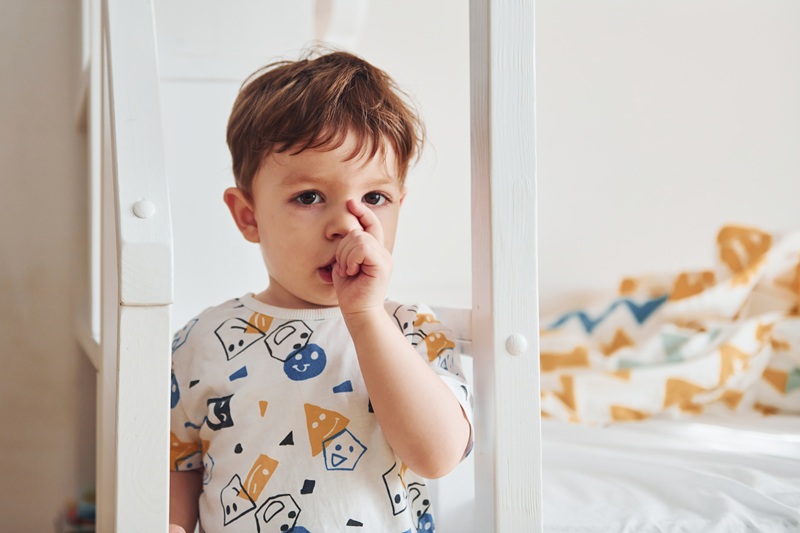 Portrait of cute little boy that standing indoors in the bedroom.