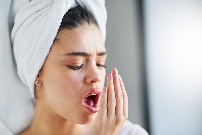 Check up on your oral hygiene. Shot of a beautiful young woman checking her breath at home